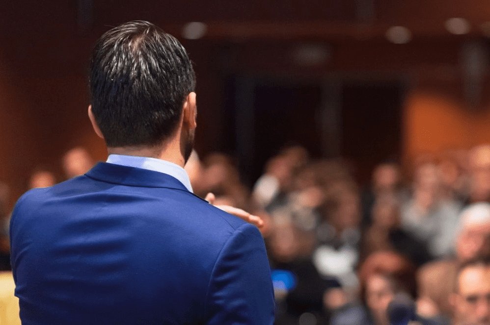 A man in a suit is giving a speech.